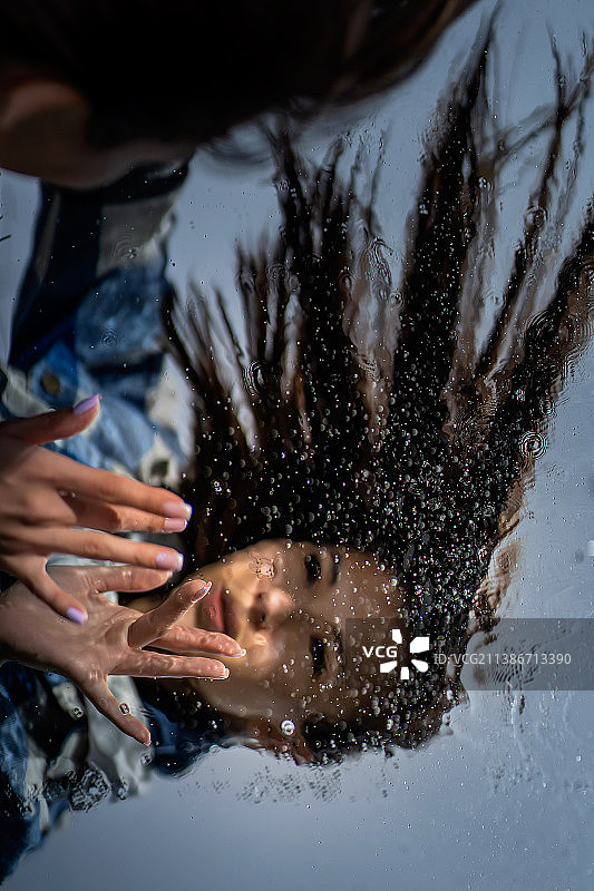 年轻女子看着水坑中的倒影，俄罗斯图片素材