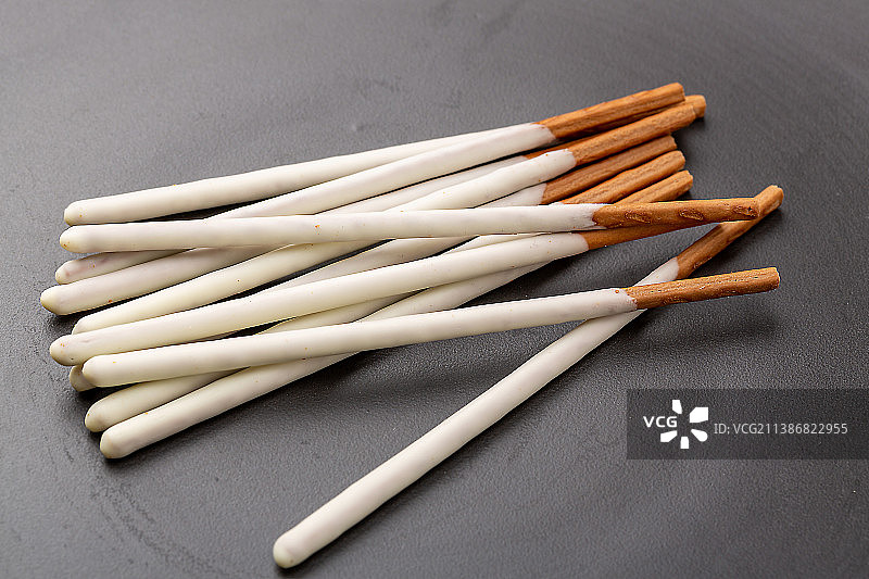 摆在盘子里的巧克力涂层长条饼干棒休闲零食图片素材