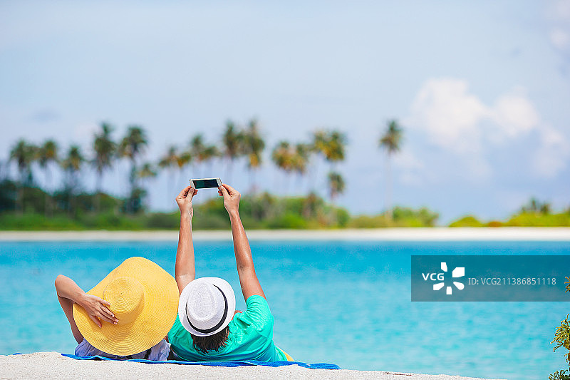 幸福情侣在蜜月旅行中于白色海滩上合影图片素材