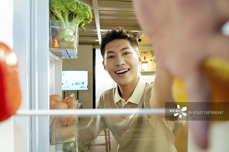 青年男人开冰箱拿食品图片素材