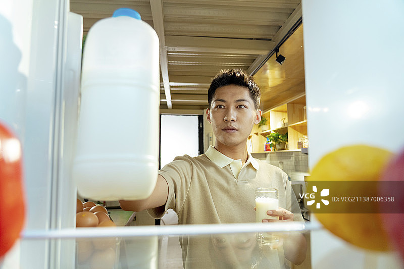 青年男人开冰箱拿食品图片素材