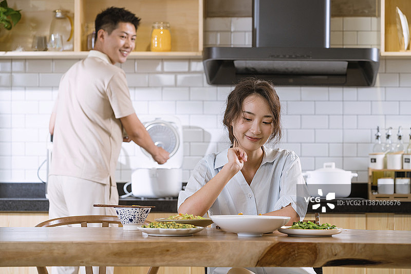 年轻夫妇在开放式厨房吃饭图片素材
