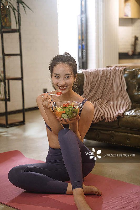 青年女人在家吃沙拉图片素材