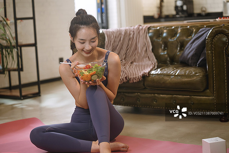 青年女人在家吃沙拉图片素材