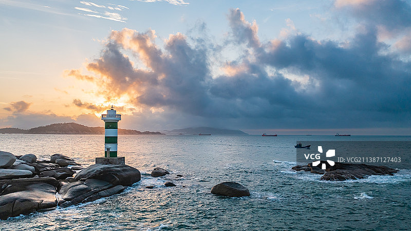 黎明的曙光下的海上灯塔图片素材