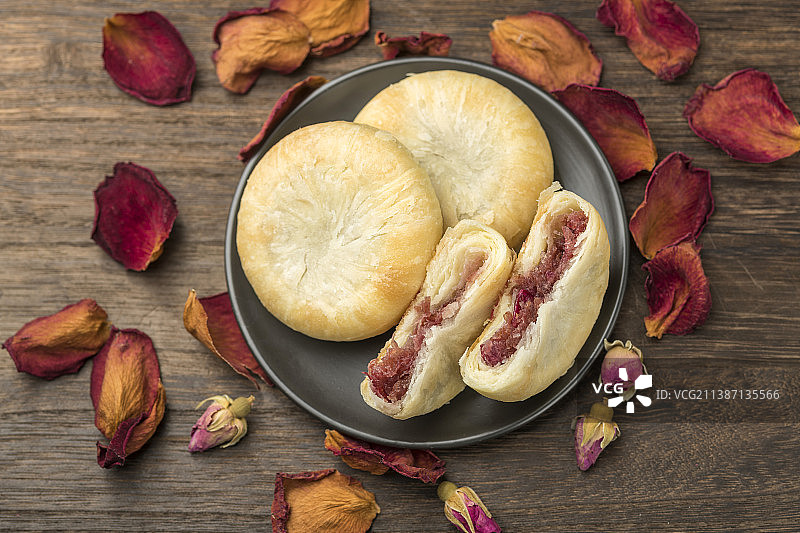 一盘玫瑰鲜花饼特写木桌面背景图片素材