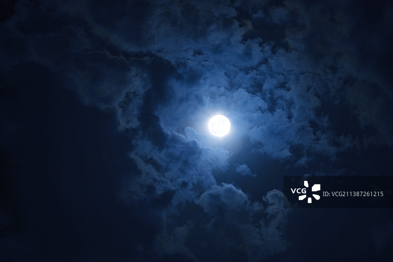 夜空中一轮满月被云雾环绕图片素材