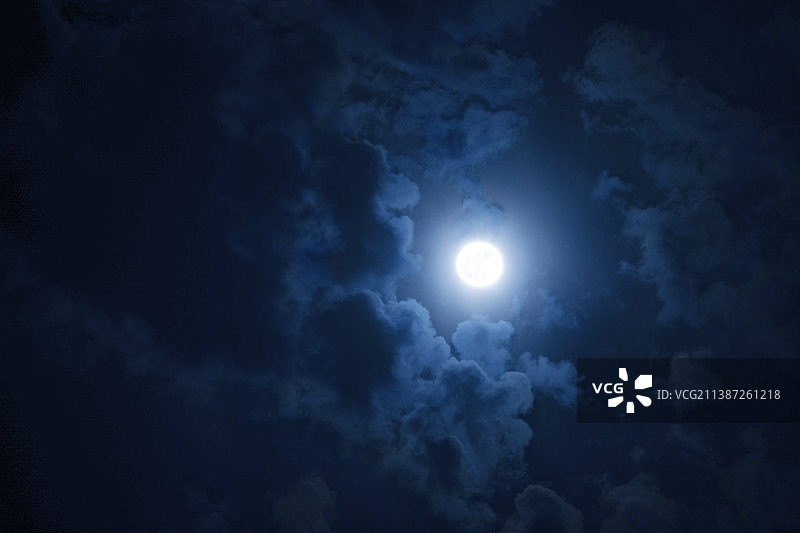 夜空中一轮满月被云雾环绕图片素材