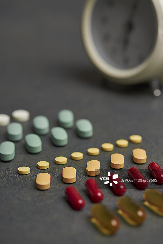 多种颜色药丸与闹钟图片素材