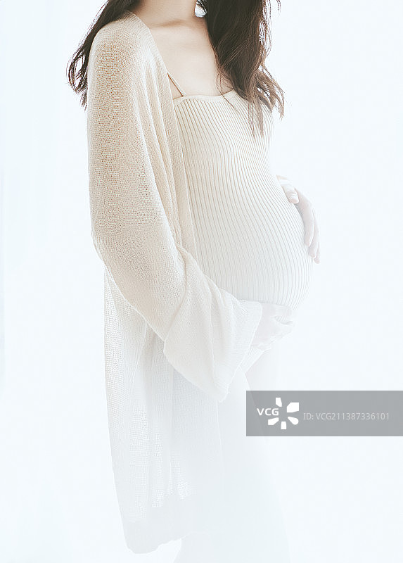 孕妇在窗前双手抚摸肚子图片素材