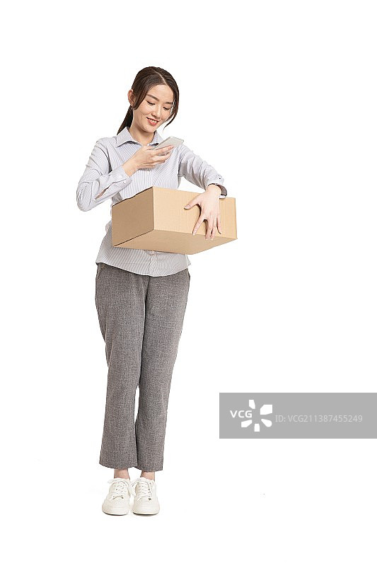用手机扫码快递盒的年轻女性图片素材