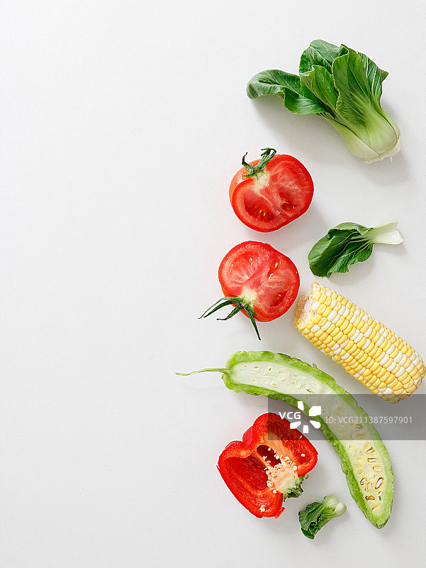 白色桌面上摆放着一堆有机绿色蔬菜瓜果图片素材