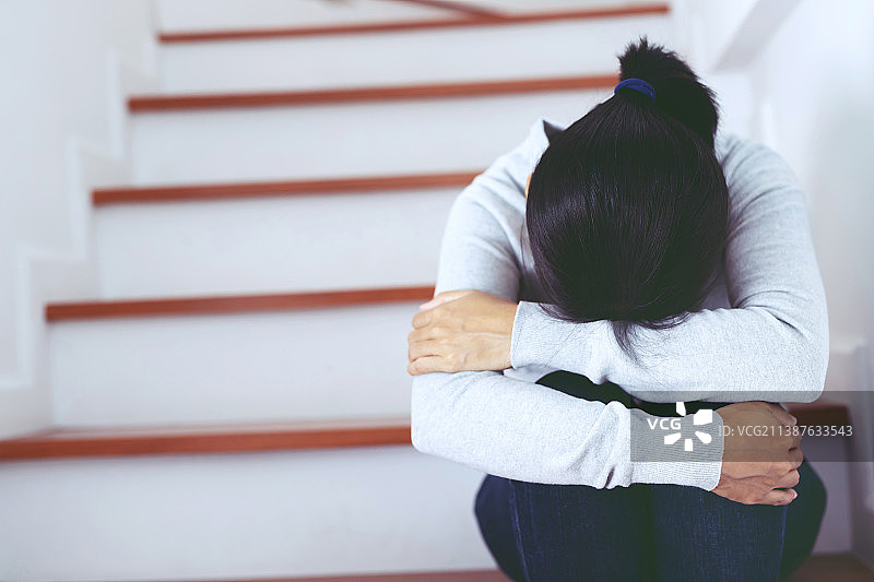 失业女性悲伤地坐在楼梯上，感到绝望图片素材