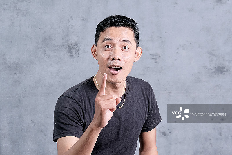 站在墙边的手势男人，印度尼西亚楠榜图片素材