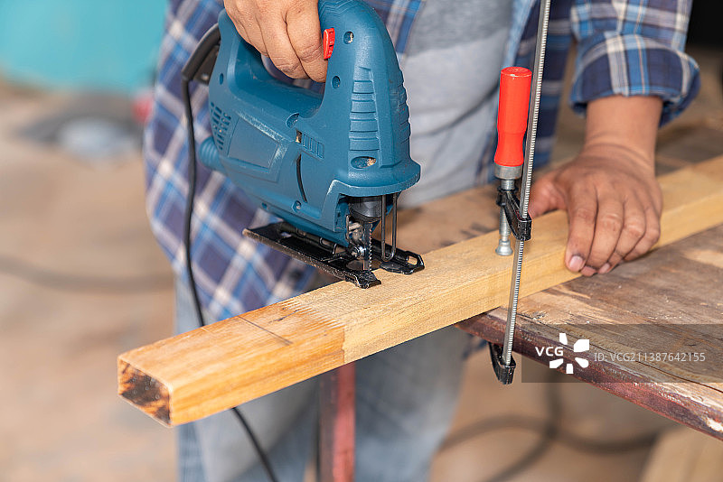 木匠用电锯和夹具锯木头的特写，泰国图片素材