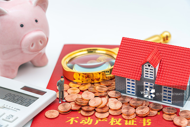 放大镜、房子模型玩具人偶放在房产证上——学区房落户概念图片素材