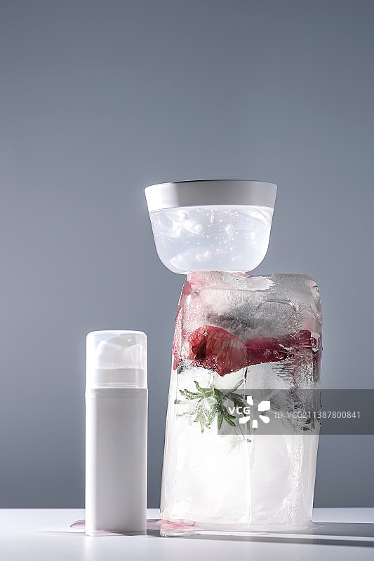 冰与鲜花背景上的凝胶和精华液罐子图片素材