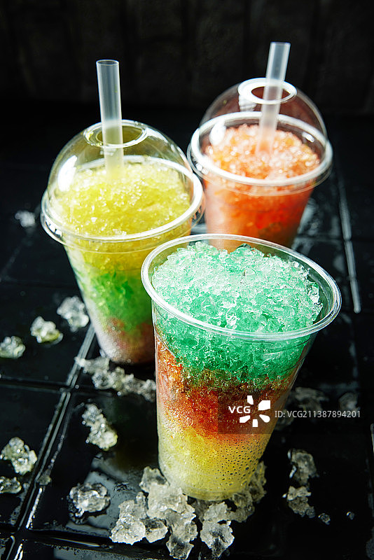 黑色背景上的三杯彩色冰沙饮品图片素材