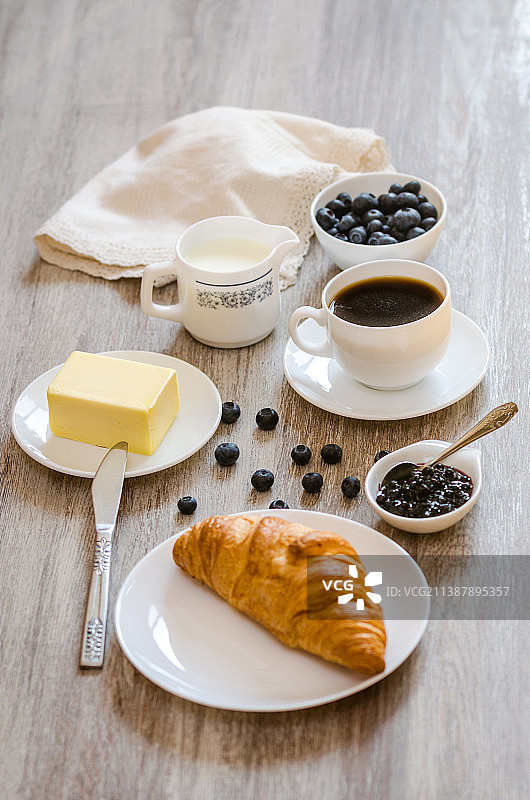 羊角面包、牛奶、黄油、越橘果酱和咖啡早餐图片素材