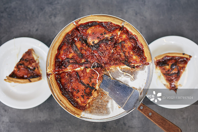 桌子上放着番茄酱的深盘披萨图片素材