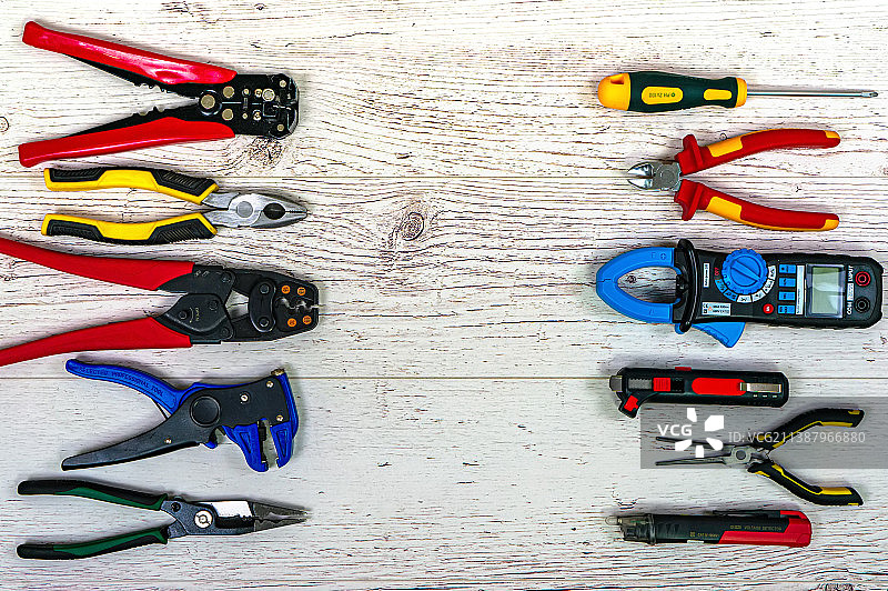 浅色木板上的专业电工工具和电气元件图片素材