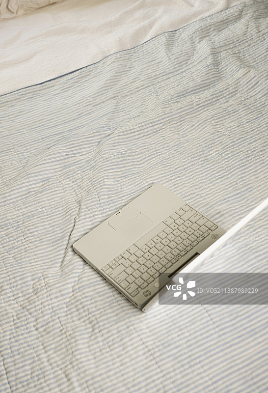 床上打开的电脑笔记本俯视图图片素材