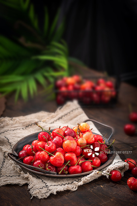 夏季复古木纹桌上的新鲜采摘的红色樱桃图片素材