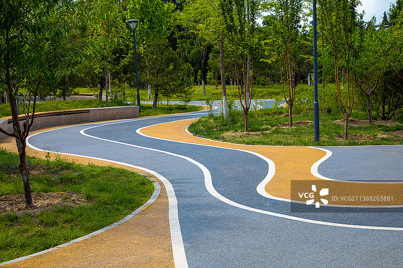 公园优美环境中弯曲向前的健身跑道图片素材