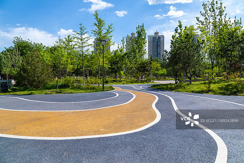 公园优美环境中弯曲向前的健身跑道图片素材