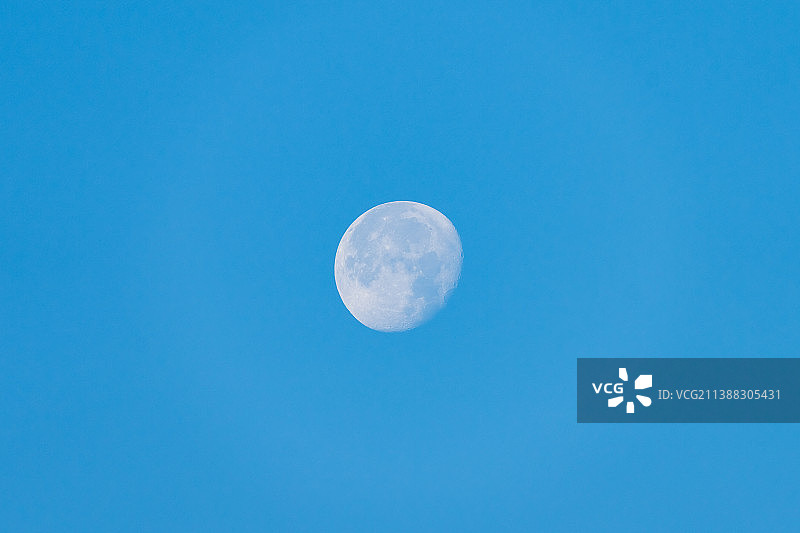 夏季白天低角度的月亮与清澈的蓝色天空图片素材