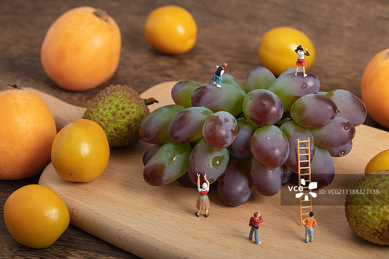 微缩创意新鲜水果搭梯子站在葡萄上的儿童图片素材