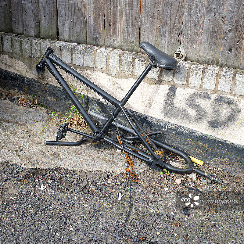 小巷里被拆卸的旧自行车和墙上的涂鸦图片素材