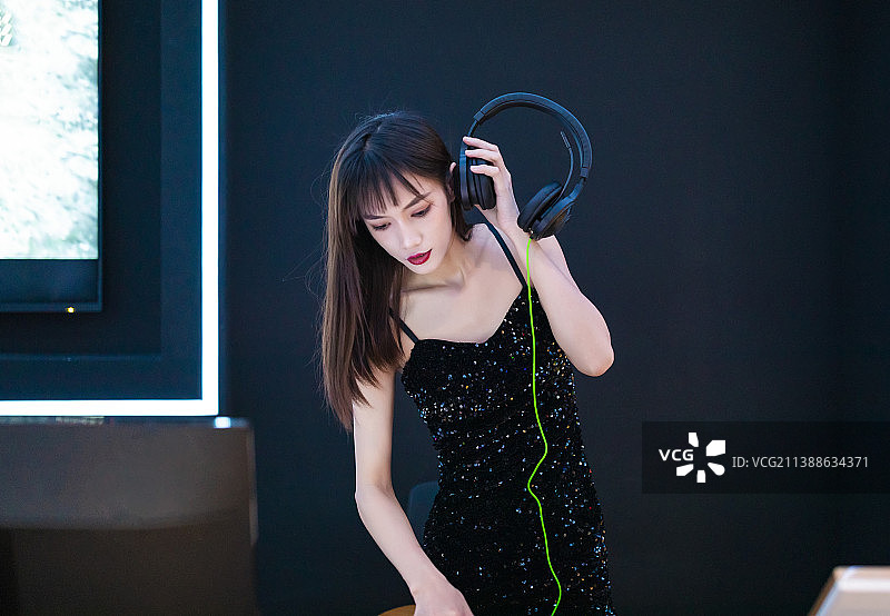 穿着性感黑色吊带裙的女DJ在打碟图片素材