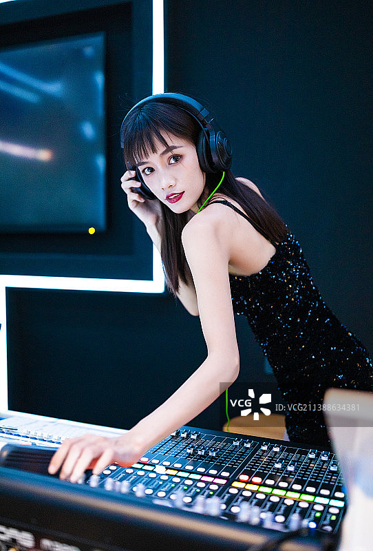 穿着性感黑色吊带裙的女DJ在打碟图片素材