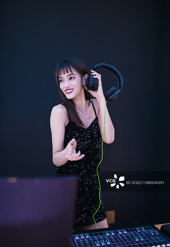 穿着性感黑色吊带裙的女DJ在打碟图片素材