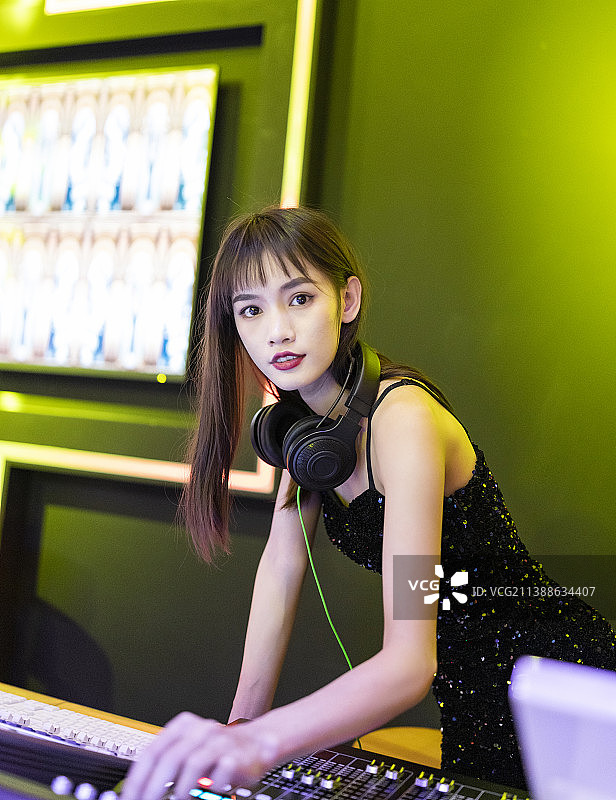 穿着性感黑色吊带裙的女DJ在打碟图片素材