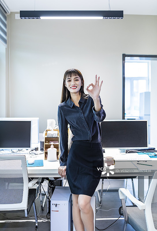 办公室里穿黑衬衣黑裙子的商务女性图片素材