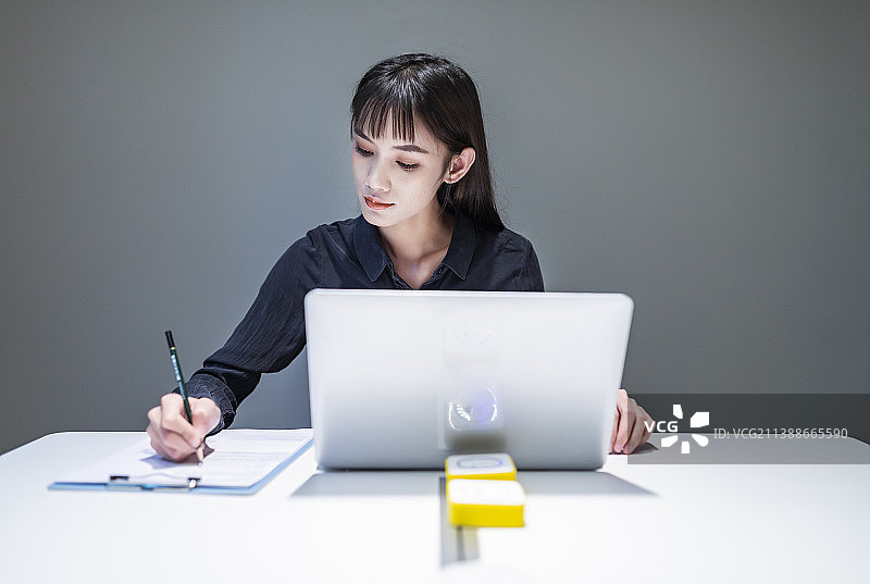 会议室里黑衬衣黑裙子的工作中的商务女性图片素材