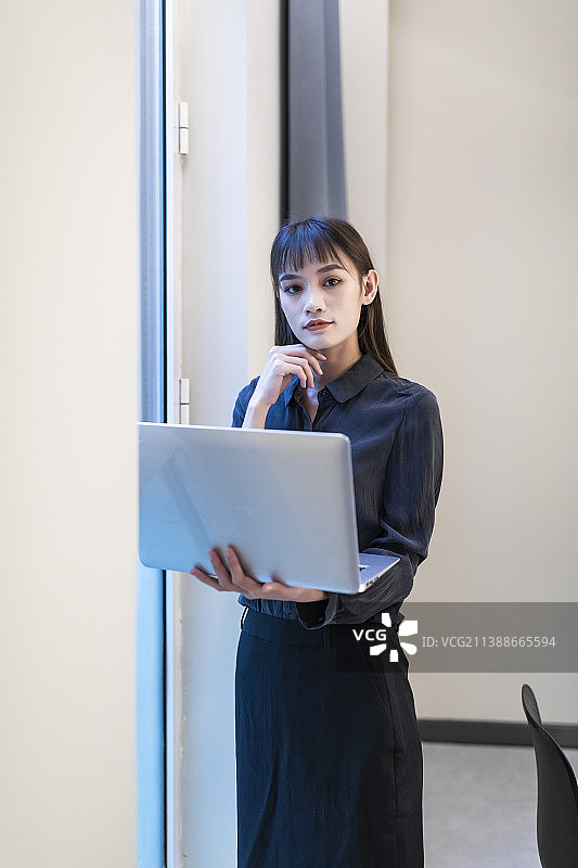 会议室里黑衬衣黑裙子的工作中的商务女性图片素材