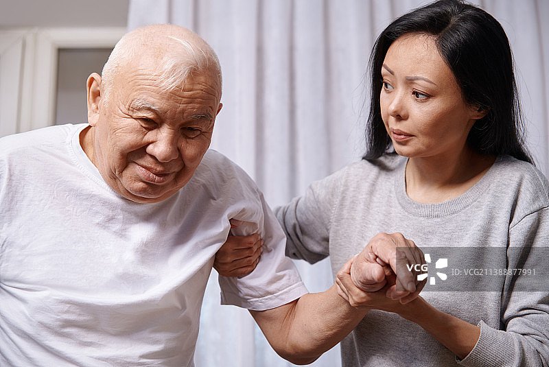 年长的男人在护理妇女的帮助下行走图片素材