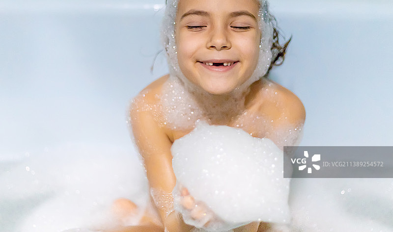 孩子在满是肥皂泡的浴缸里洗澡图片素材