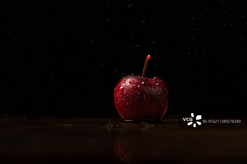 黑色背景下的湿苹果特写图片素材