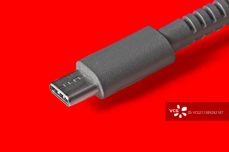 红色背景上的USB Type-C连接线特写图片素材