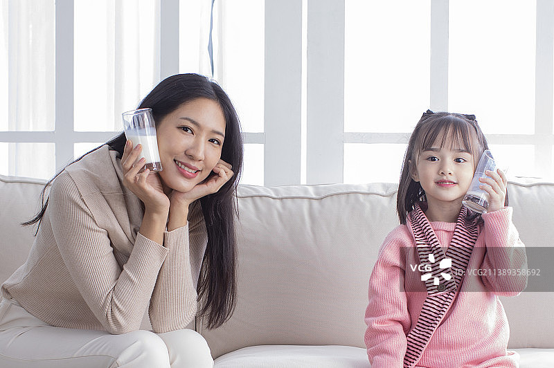 美女妈妈和可爱女儿喝营养又健康的牛奶图片素材