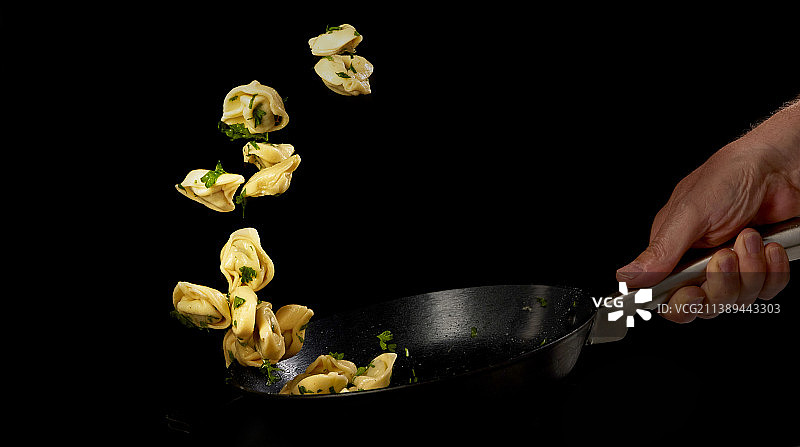 厨师在煎锅中翻炒饺子图片素材