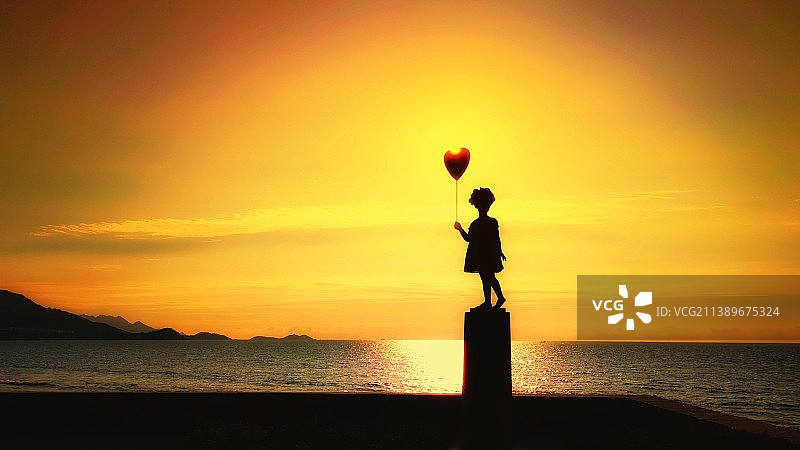 沐浴在霞光中的雕塑小女孩图片素材