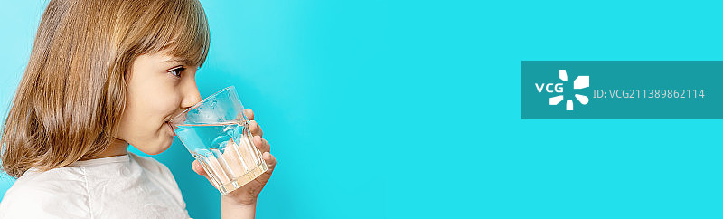 女孩喝玻璃杯里的水（选择性聚焦）图片素材