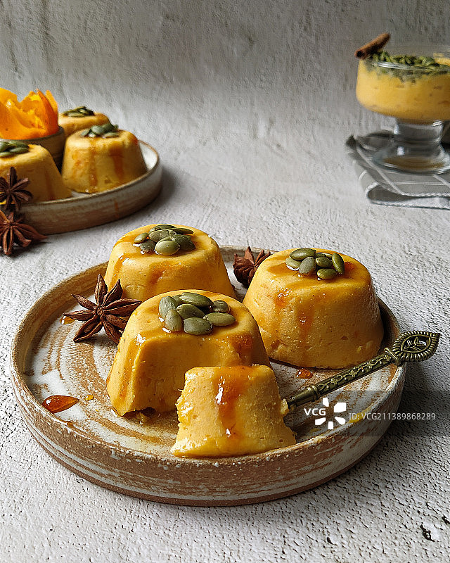 灰色背景上的南瓜意式奶冻配南瓜籽图片素材