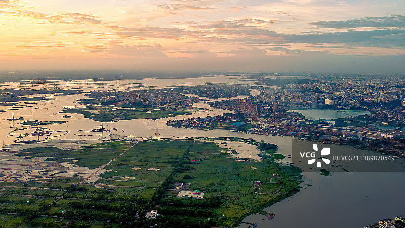 孟加拉国达卡，日落时分建筑物之间的河流高角度视图图片素材