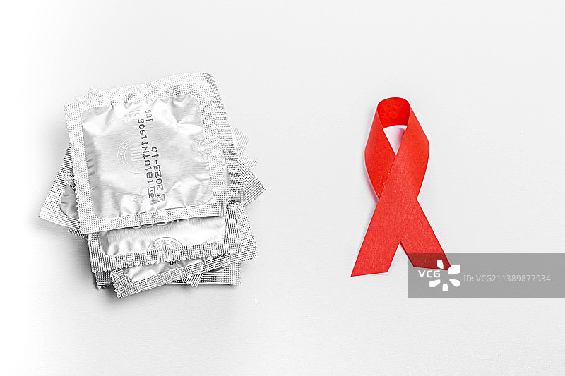 白色背景上的避孕套和红色丝带图片素材